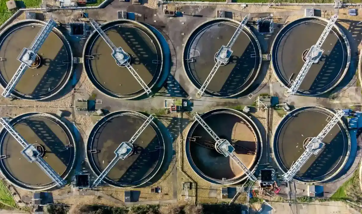 Instalação de tratamento de águas residuais com múltiplos tanques circulares para sedimentação e oxigenação. O sistema remove impurezas e contaminantes da água usada, tornando-a adequada para reuso ou descarte controlado.